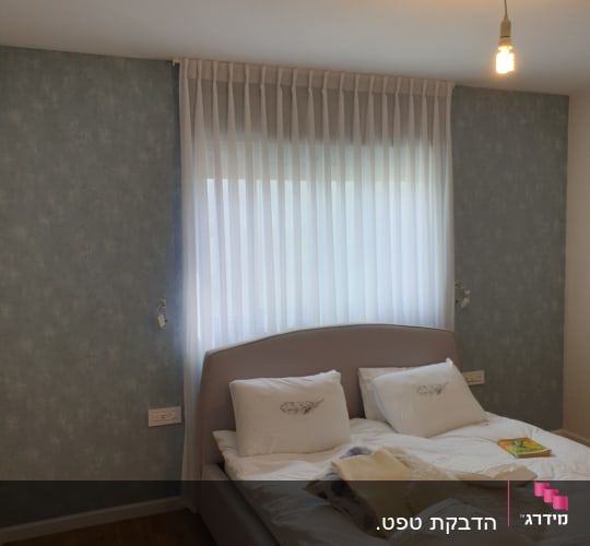 טפט כחול עם דוגמה עדינה על קיר חדר שינה